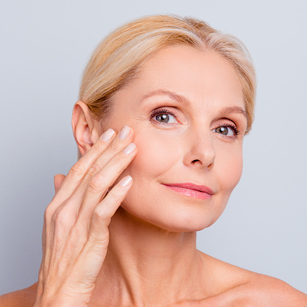 woman touching, enjoying her perfect face skin
